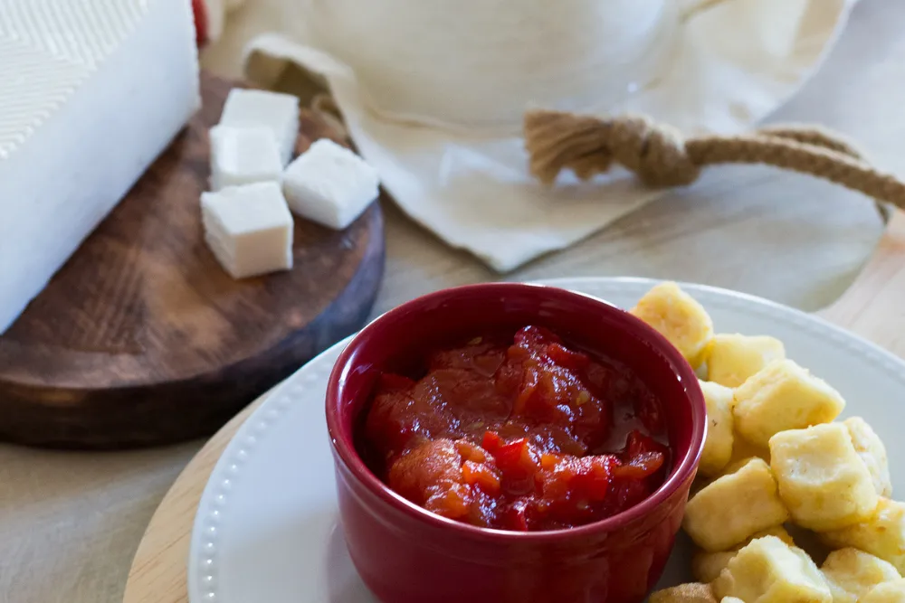Queso frito con mermelada de tomate con dados de queso fresco al fondo