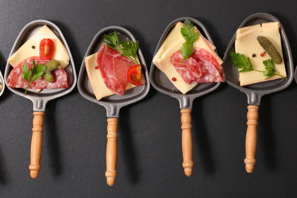 Una foto de vários acompañantes para el queso raclette.